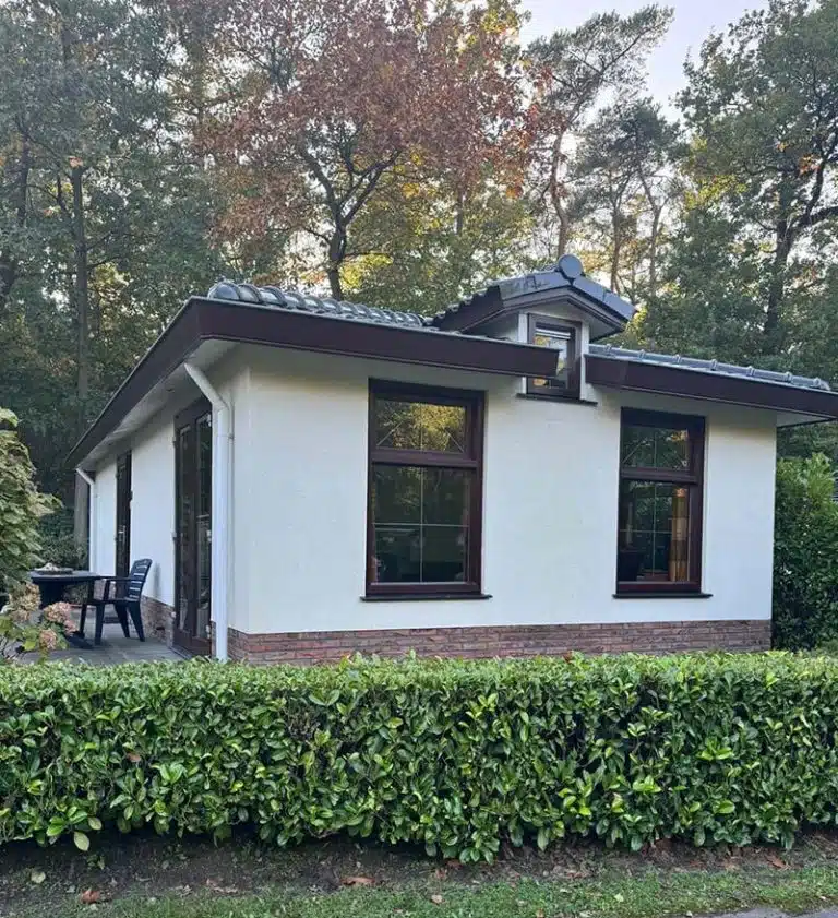Wit vakantiehuis De Wulp achter een groene haag